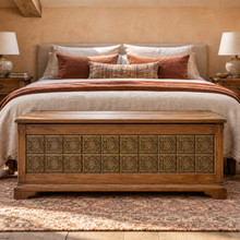 Fine Ring Knot Celtic knot tiles in hand-embossed brass, inlaid in the front of a wooden blanket chest at a bed's foot