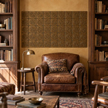 Trefoil Circle Knot in hand-embossed brass, as a wall panel between bookcases above a leather armchair in a library