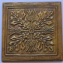 Front view of one 8 inch square hand-embossed solid brass thistle tile in aged bronze with its 6 mm raised rim