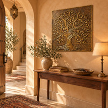 One 20 inch hand-embossed solid brass swirl Tree of Life panel in aged bronze hung above a console table in an entrance hall