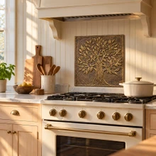 One hand-embossed brass broadleaf Tree of Life panel in aged bronze as a backsplash panel behind a kitchen range
