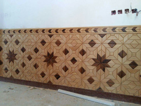 High-contrast light and dark star and diamond wood mosaic wainscot panel installed on a wall