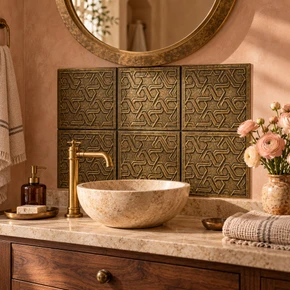 Hand-embossed solid brass Marrakesh lattice tiles in aged bronze as a bathroom vanity backsplash above a basin