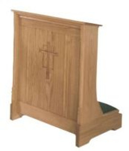 Rectangular wooden structure with a kneeling pad and decorative cross carved into the front.