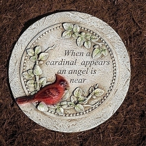 Cardinal Memorial Stepping Stone. The stepping stone measures 10.25" in diameter. The Cardinal Memorial Stone is made of a resin stone mix. On the stone is written: "When a cardinal appears an angel is near." On the stone is depicted a cardinal sitting on branches with green leaves 