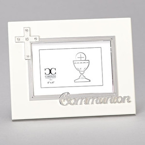 7"H White Holy Communion Photo Frame. The white communion photo frame has a white enameled cross on the upper left corner with crystals. The word Communion are also written on the bottom. Frame holds a 4" x 6" photo. Made of zinc alloy-lead free