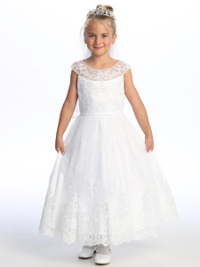 Little girl smiling in a white Communion dress with embroidered tulle.