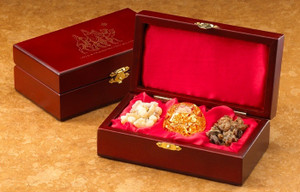 The Original Gifts of Christmas ~ Gold Frankincense & Myrrh
A silhouette of the Magi following the Christmas star - printed in gold - tops the lid of a richly detailed box.  The cherry stained finish of a solid wood chest is offset by the unique brass latch. The box makes a beautiful, meaningful and dramatic presentation.  The interior of the box is striking with its luxurious red satin lining on both the padded lid and base. The large tears of frankincense, hand-blown glass ball with 23kt gold inside and crystals of Arabian myrrh are nestled together in this beautiful collection of the Gifts of the Three Kings.
- Authentic 23 K Gold in Hand Blown Glass Orb 
- Authentic Frankincense & Myrrh, too 
- Satin Lined Hand-Crafted Wood Display Case 
- Wonderfully Gift-Boxed 
- Certificates of Authenticity and History & Care Instructions included.
6.75 x 3.75 x 2.00.Image of a hand-crafted wood display case propped open with gold, frankincense, and myrrh setting inside.