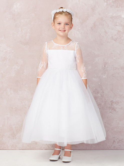 Product Description:
This beautiful communion dress features an elegant lace illusion neckline, paired with a three-quarter length sleeve, and tulle a-line shirt. Order yours today from St. Jude’s Shop!
Features
Three-quarters sleeve 
Illusion Lace-Neckline
Tulle Skirt 
Scooped Neck 
This classic First Communion dress’s elegant lace bodice creates a beautiful illusion, swoop style neckline. A simplistic design with an ankle length tulle skirt creates the perfect symbol of grace for your little princess’s big day. 
Ankle Length 
Made in the U.S.A. 
3 Dress Limit Per Order

 