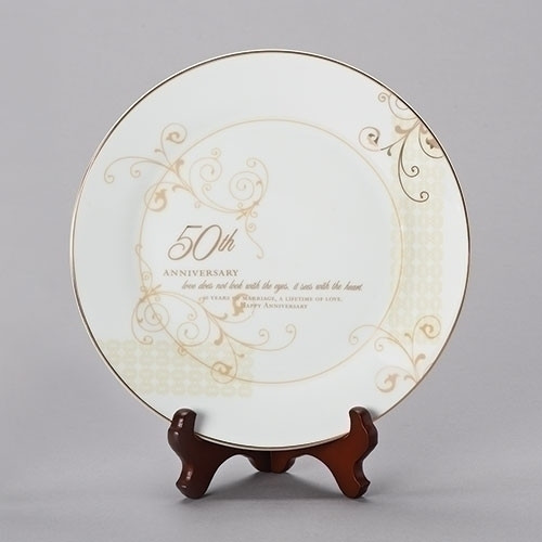 Porcelain 9"H 50th Wedding Anniversary Plate. This 50th Wedding Anniversary Plate stands 9"H and had gold scrolling. Plate comes with a stand. "Love does not look with the eyes, it sees with the heart. 50 years of marriage and a lifetime of love. Happy Anniversary" is written on the white and gold plate. Measurements are: 9.25"H 9.25"W 1"D. 