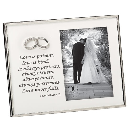 7"H white enameled wedding frame holds a 4X6 photo. Frame is white enamel with silver edging  around outer frame.  The verse 1 Corinthians 13 is printed on left side of frame under the double wedding bands. Materials: Iron