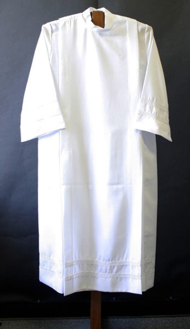 Alb in 100% smooth poplin polyester for easy care. One inch woven lace bands on cuffs and on the bottom of the garment. Your choice of velcro or button closure. Ample Cut sizes available upon request, please contact us at 800-523-7604 for details. (See sizing charts below product descriotion) 