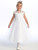 Little girl smiling in a white Communion dress with embroidered tulle.