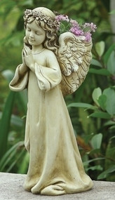 A praying angel cement statue with pink flowers tucked behind her wings in an outdoor garden. 16" "Praying Angel Garden Planter" Angel Planter is 16"H x 7" W x 9"D. The Praying angel Planter is made of a resin/stone mix. A beautiful addition to any inside or outside garden!!