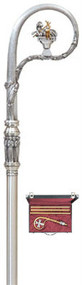 Crozier with Agnus Dei symbol and six adorning angels on the node slightly oxidized. Crook section is richly textured metal with soft finish on 3-piece shaft and rubber tip on end. 71" height. Available in Silver Plate or 24K Gold plate   Price includes sturdy lined case with lock and key. Outside dimensions: 20" x 13-3/4" x 3-1/2" deep