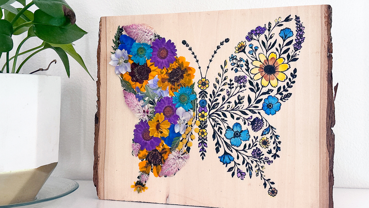 Pressed flower butterfly wood sign made with Ikonart stencil and acrylic paint