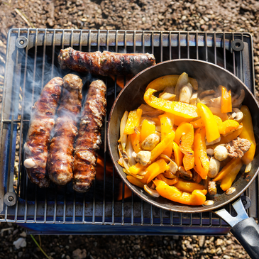 Seek Outside stove grill top in use with fire burning inside, preparing a hot meal at camp.