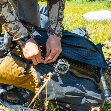 a person adjusts the gatekeeper compression straps on Goshawk backpack