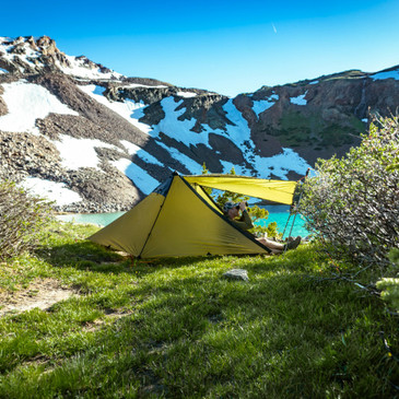 Guardian shelter interior with hunter seated at entrance, binoculars raised, 103-inch length providing spacious two-person layout