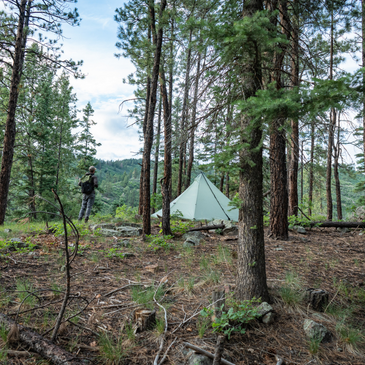 backpacker stands next to seek outside cimarron pyramid tent