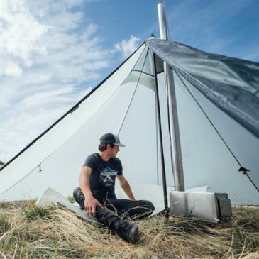 person sits inside Cimarron Light hot tent with ample headroom