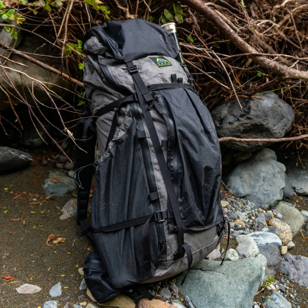 Goshawk 6300 side view by creek showing UltraStretch side pockets, and water-resistant zippers
