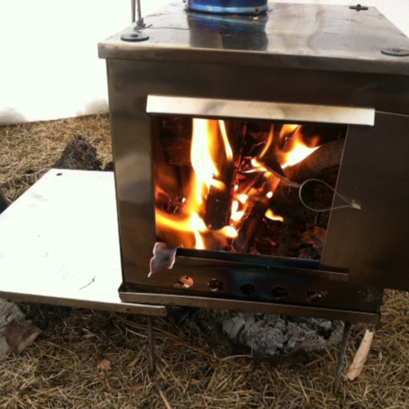 utility tray attached to stove legs used as a side drying or cooking shelf
