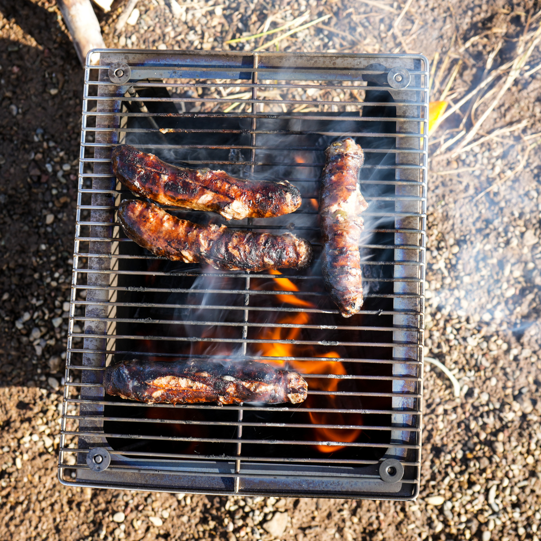Seek Outside Titanium stove, roaring fire inside cooks food on the Grill Top upgrade