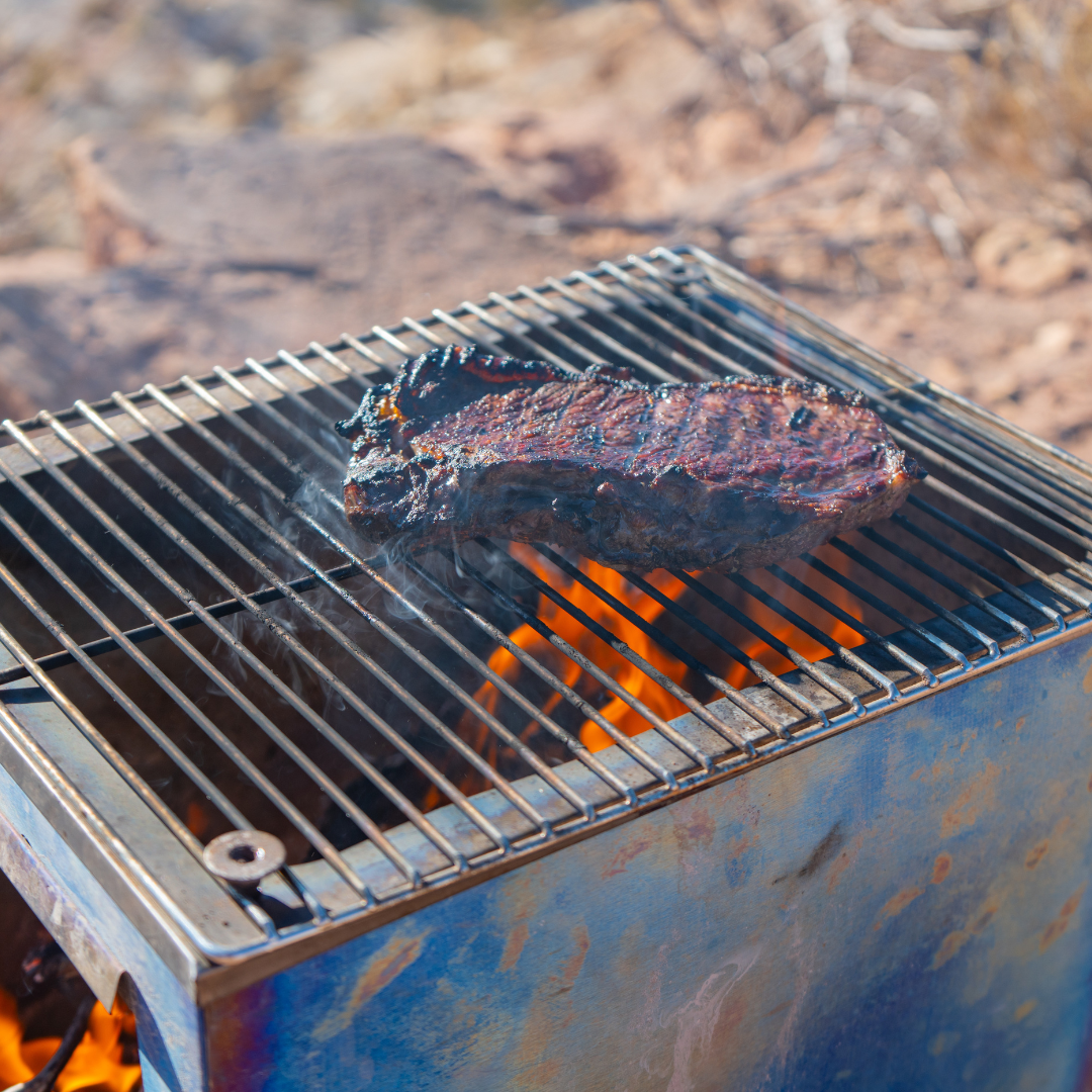 Camp cooking on Seek Outside stove grill top with fire roaring 