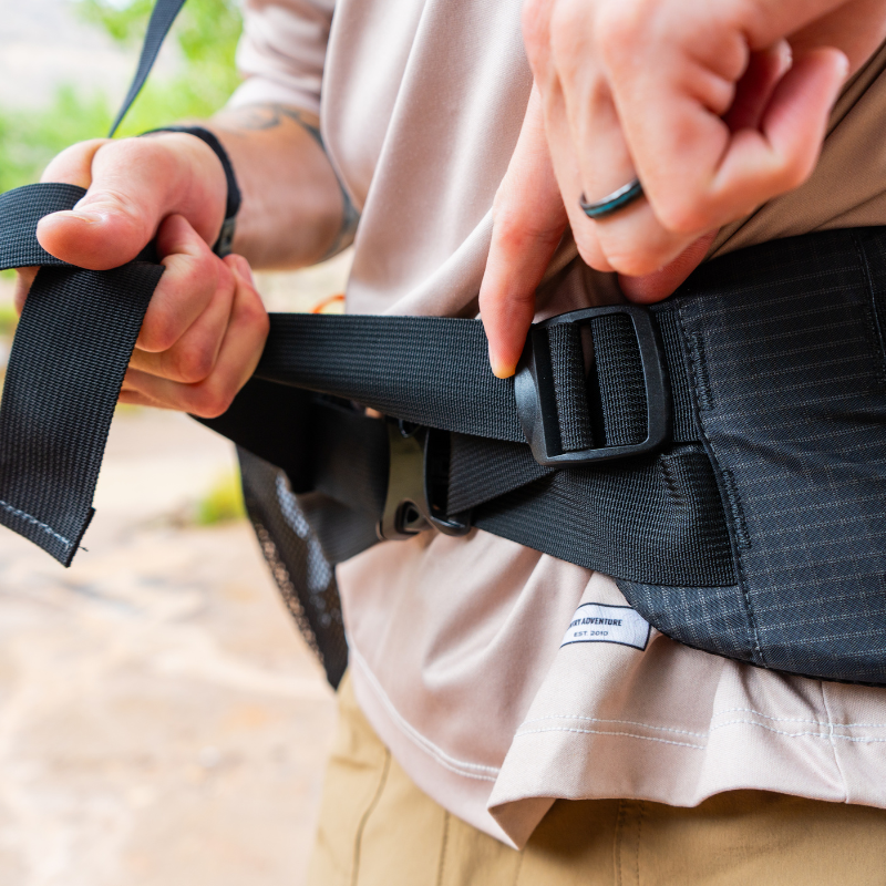 a man adjust the hipbelt on a seek outside Gila backpack