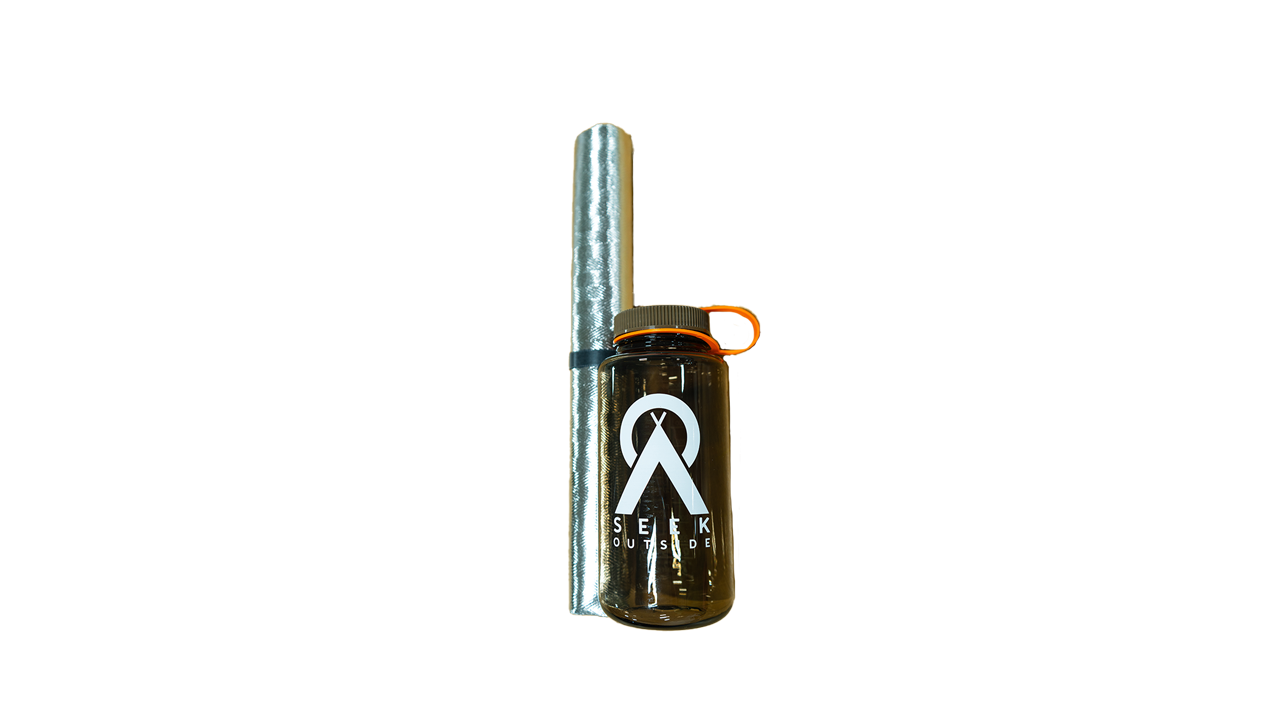a silver fire mat rolled up next to a Nalgene water bottle for size comparison