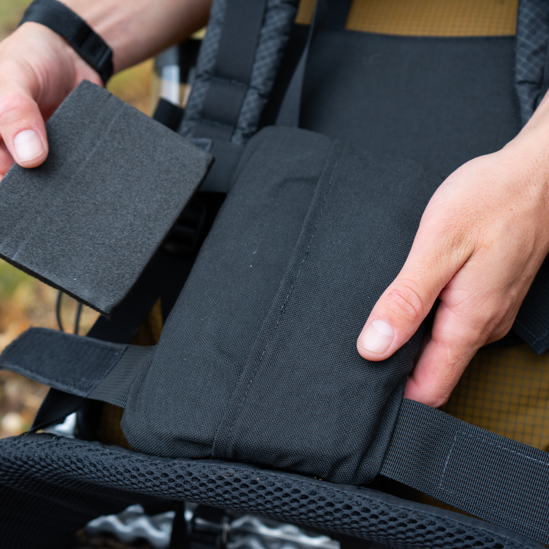 a man adjusts the foam insert on a lumbar pad