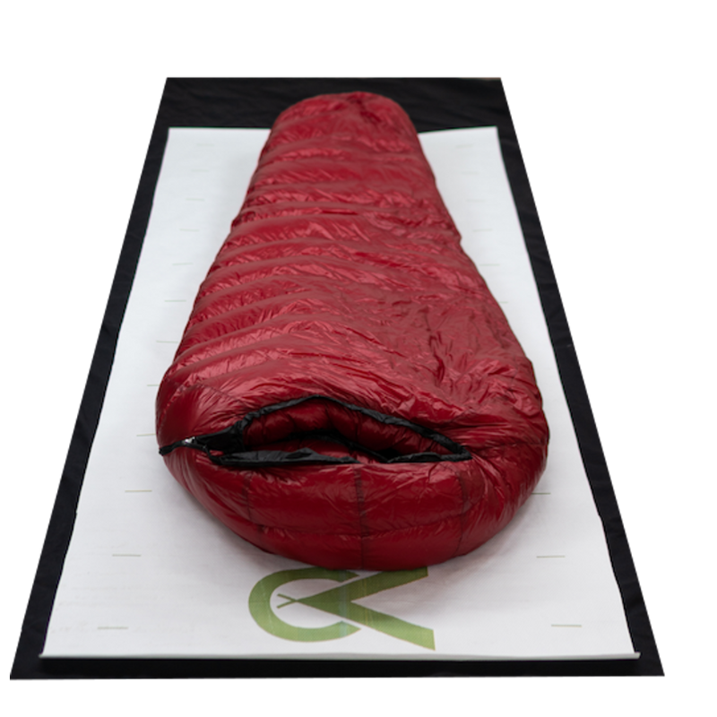 a red sleeping back on top of a ground sheet, on top of a matty ground mat