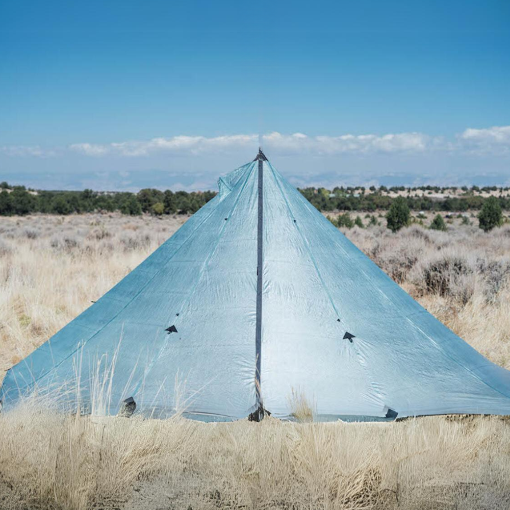 a sage DCF redcliff tent is set up in a grassy field with clear blue skies