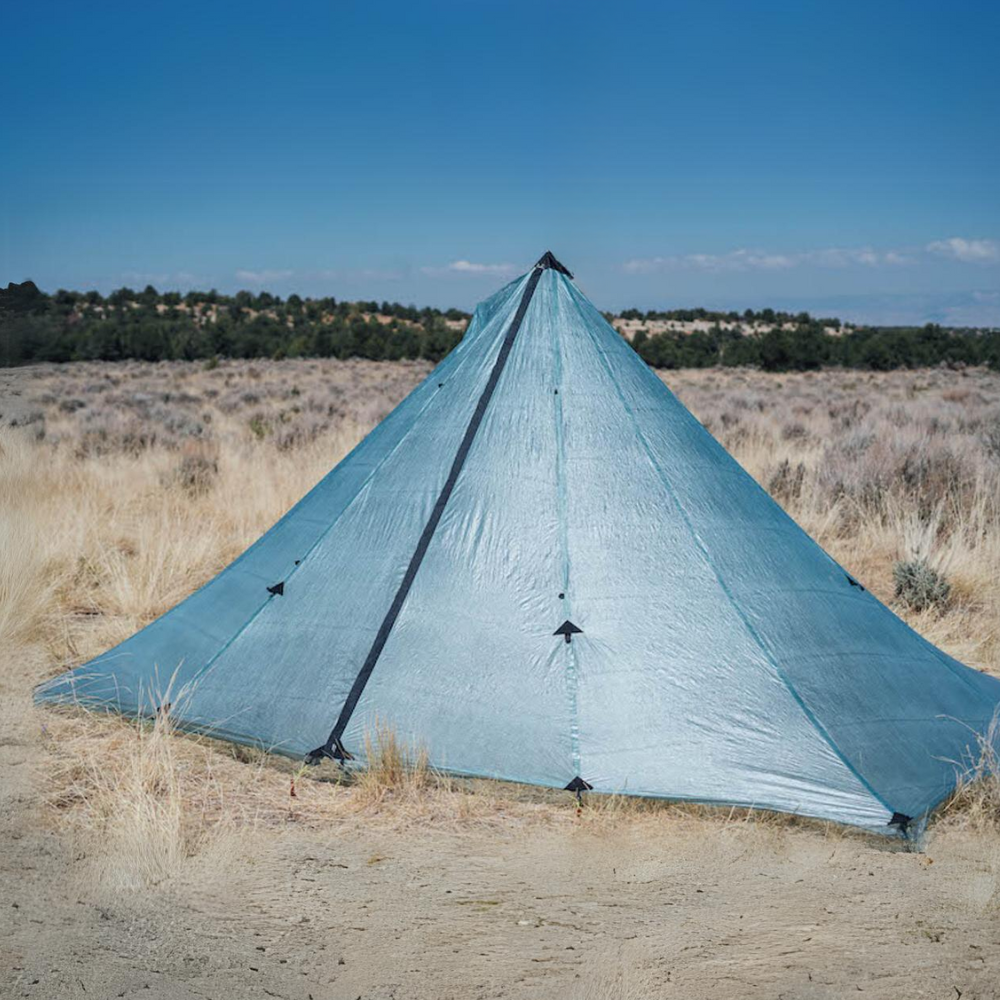a sage DCF redcliff tent is set up in a grassy field with clear blue skies