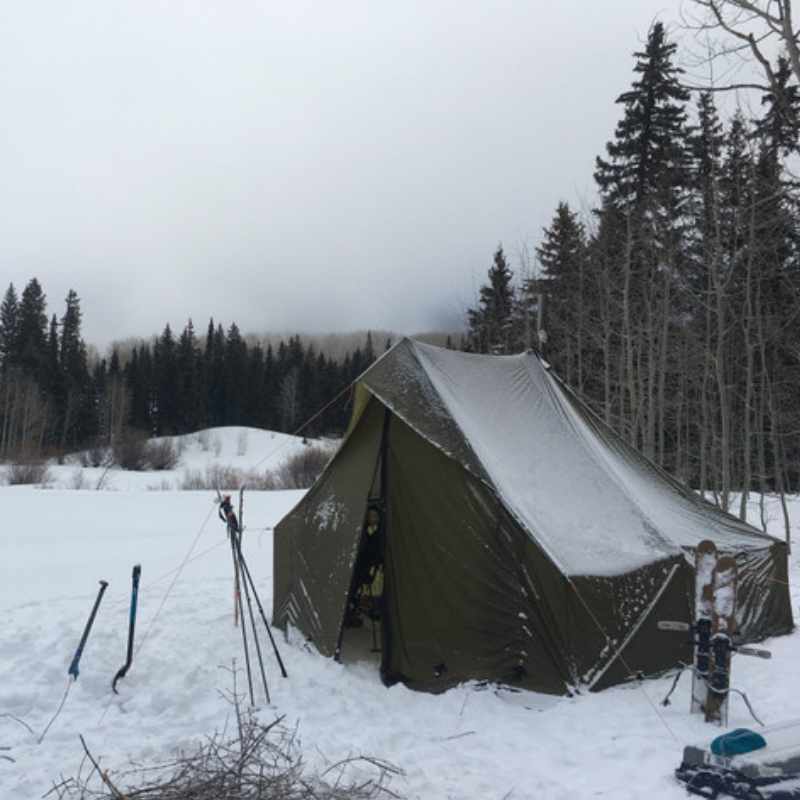 A frost covered Courthouse tent set up in a snowy winter forest