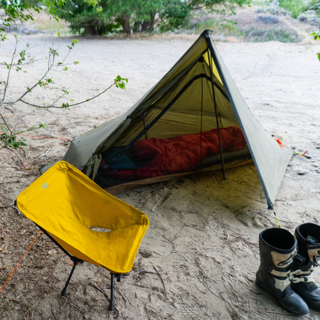 a Brightwater nests is set up inside a tent, camping gear is inside the nest and nearby
