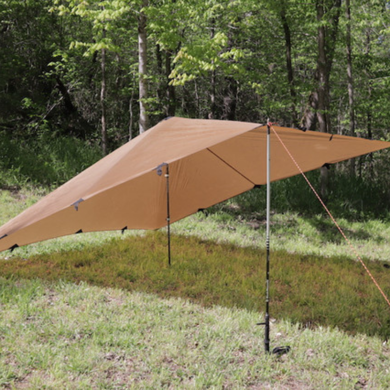 dst tarp set up in diamond shape with the front and middle elevates with trekking poles, surrounded by trees and on a grassy field