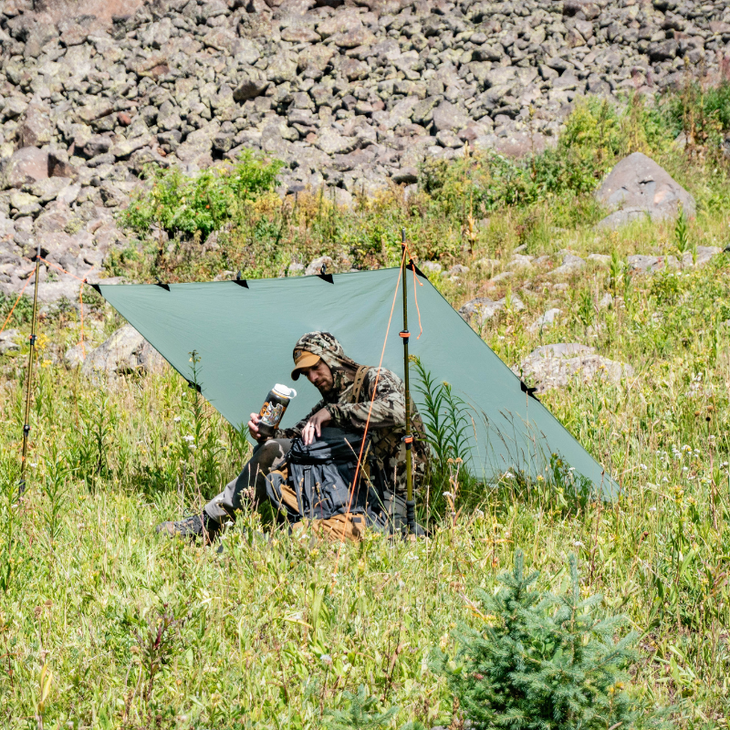 Tarp Set up On Hillside with person using it.