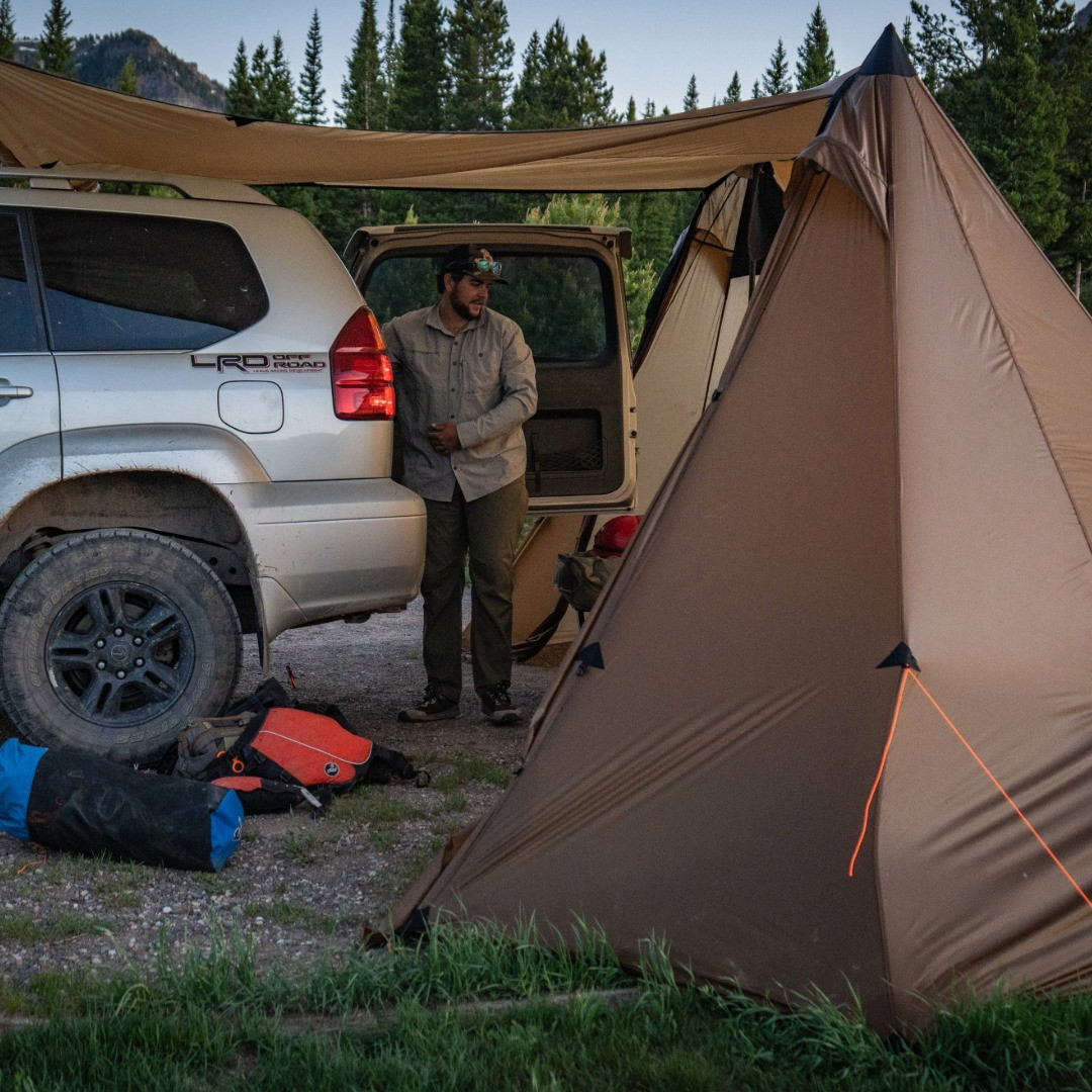 bookcliff tent, with awning open and a silver SUV backed up into the tent