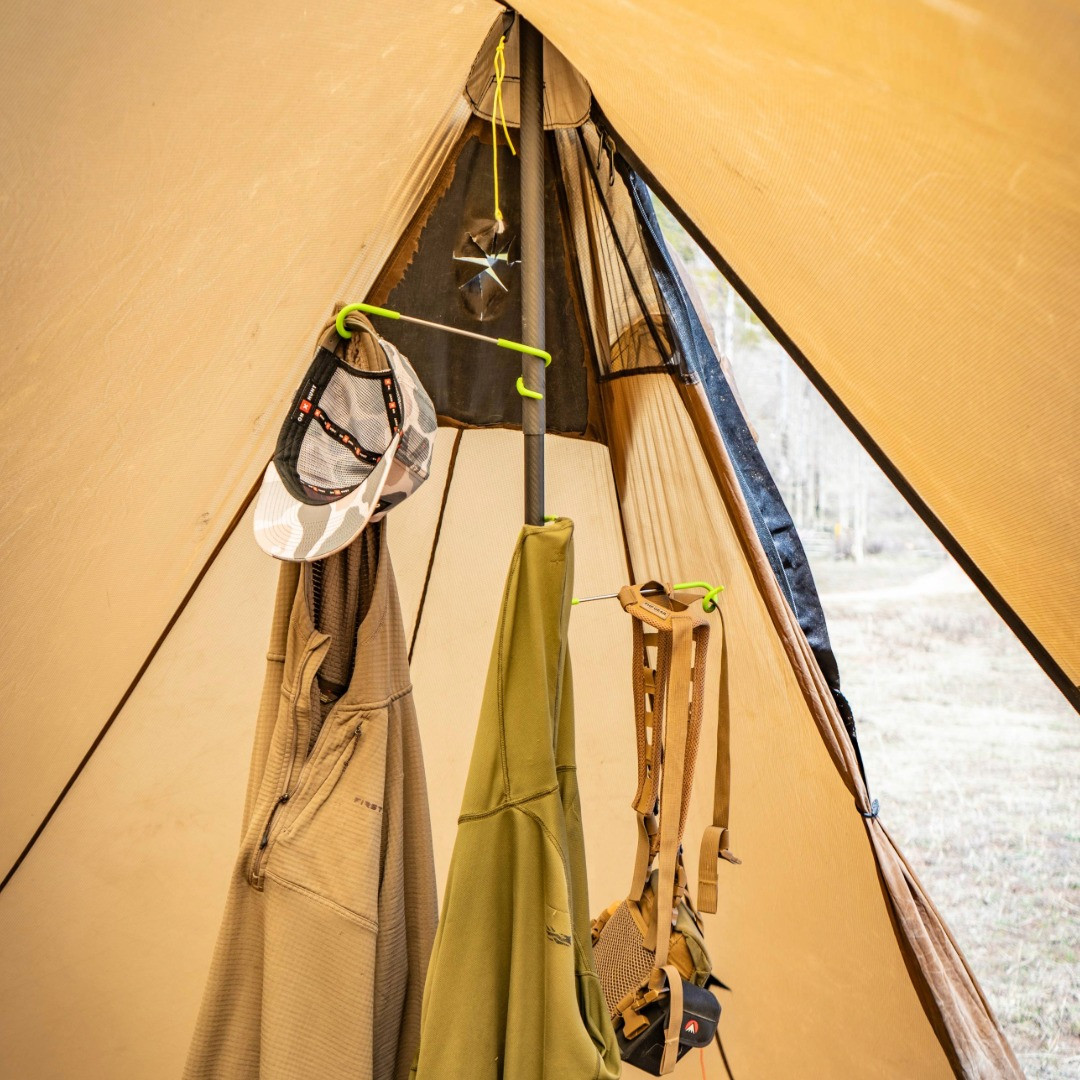 pole hooks connected to a tent pole with a hat and clothes hanging from them