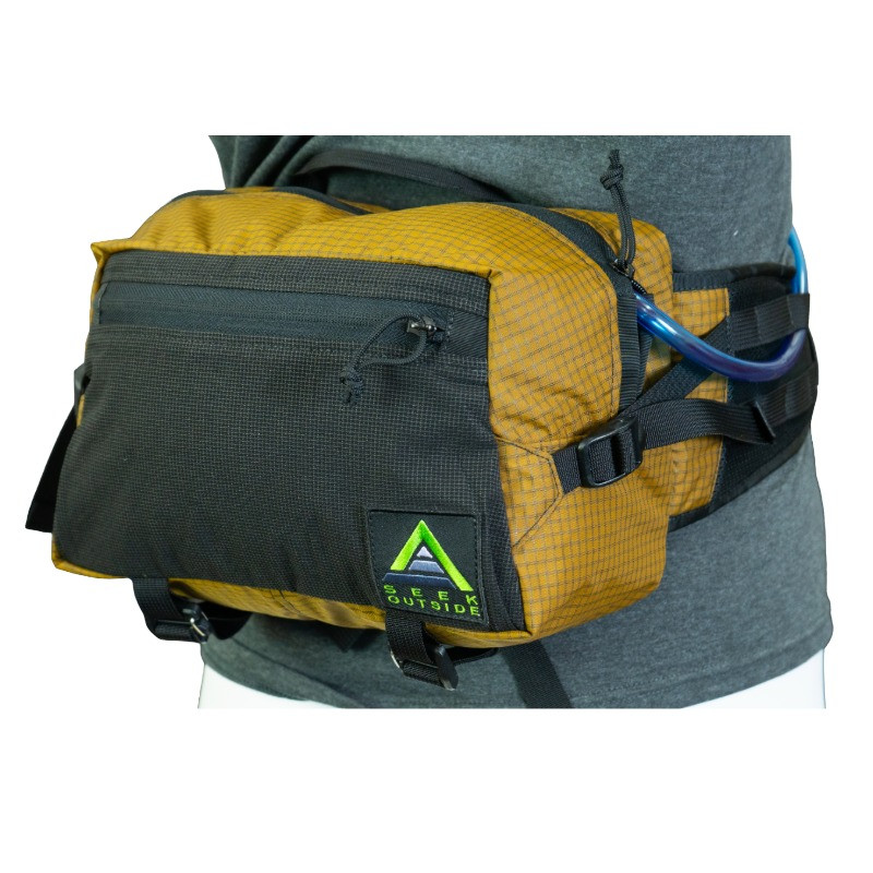 Mesa hip pack side view showing left hydration port, Ultra Stretch pocket fits up to 2L bladder, access port for tube