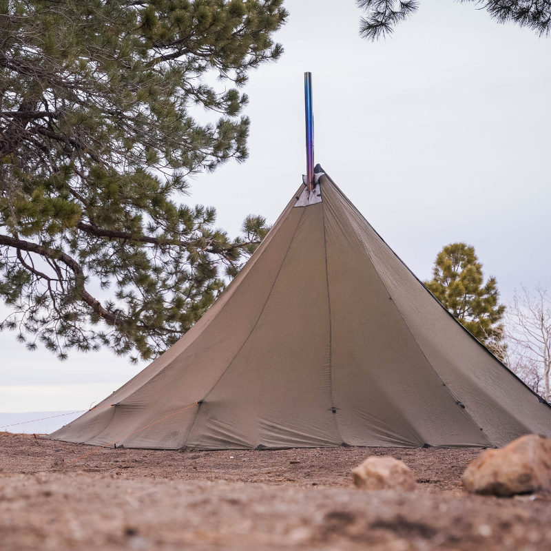 backcountry tipi tent staked in rocky ground, guyout loops reinforced and stove jack rain flap visible