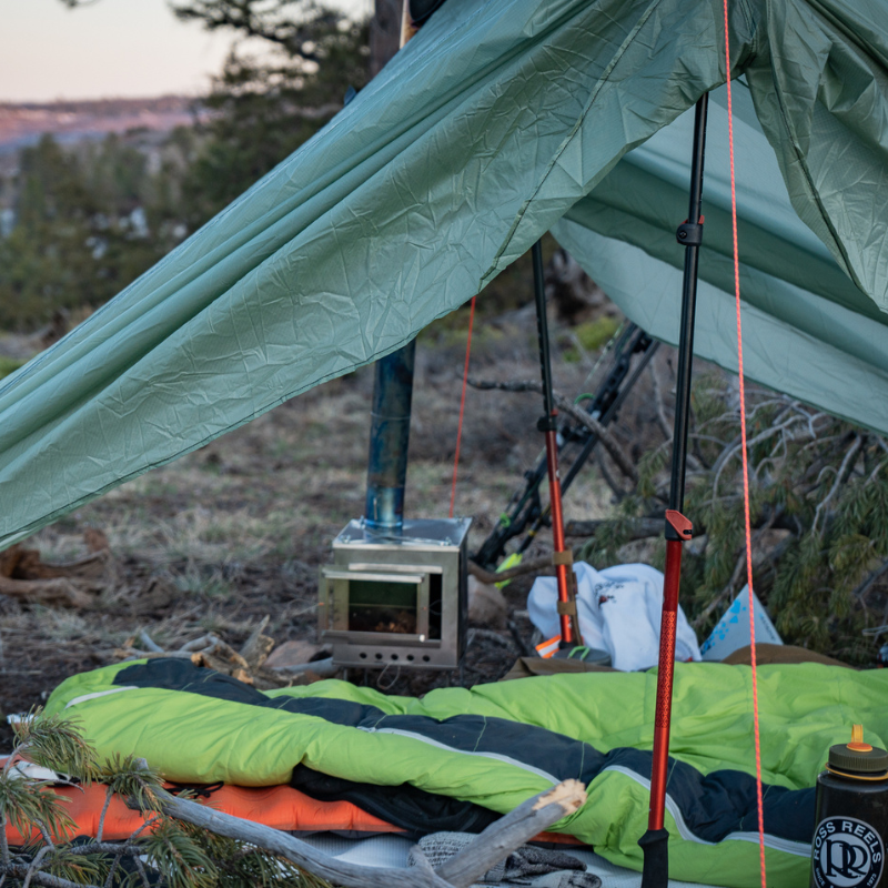 medium wood burning stove and gear inside an Seek Outside tent