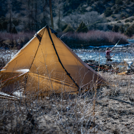 Cimarron tent pitched on grassy riverbank with 6-foot center height, sod skirt keeping out insects and debris