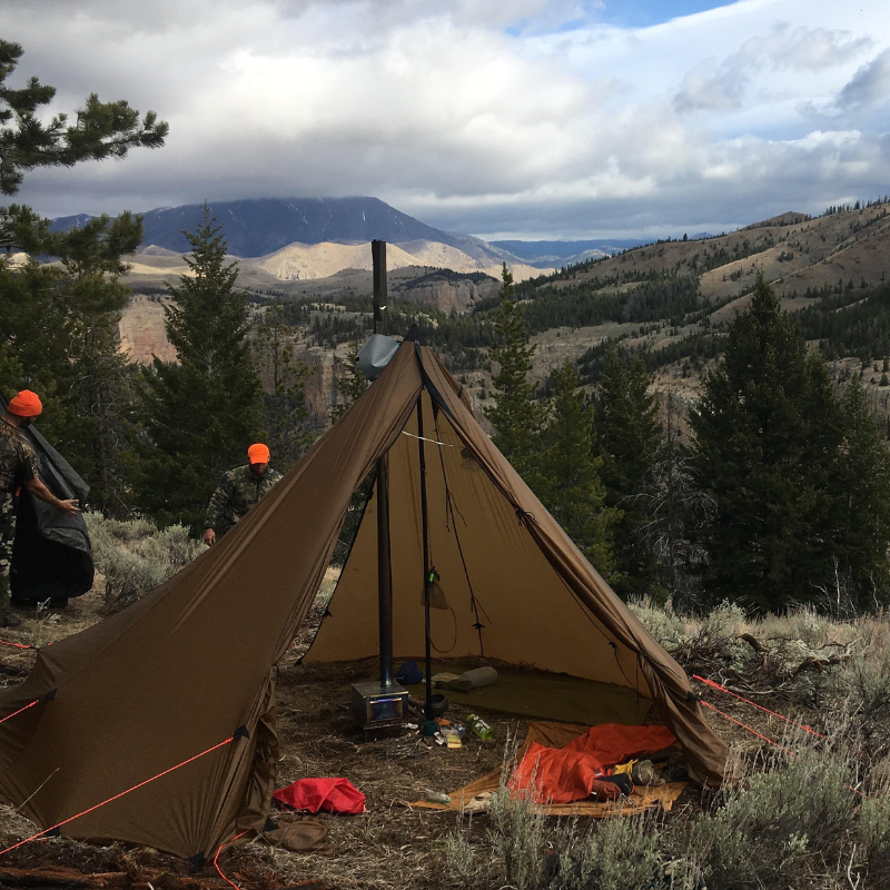 Hunters organizing camp with 6-person tipi with titanium stove, sleeping pads, and gear arranged in 145 square feet