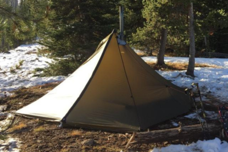 Cimarron tent pitched in pine forest with 6-foot center height, sod skirt keeping out insects and debris