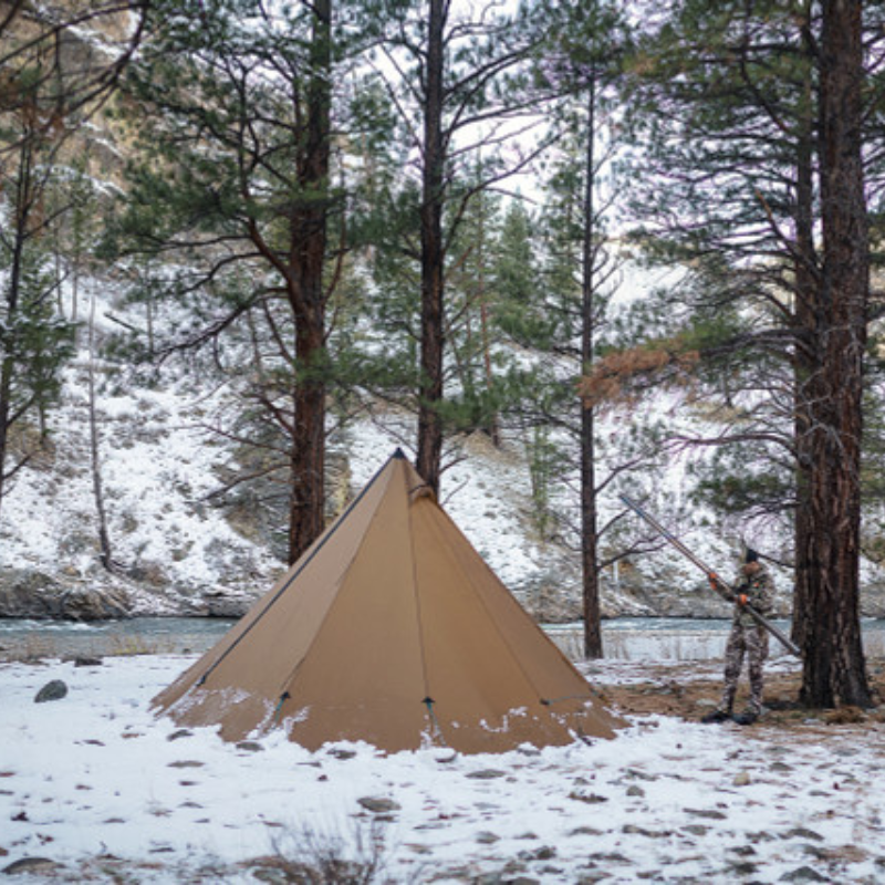 Seek Outside tipi tent pitched in snowy meadow with 8 foot 6 inch peak height, snow piled around sod skirt for insulation