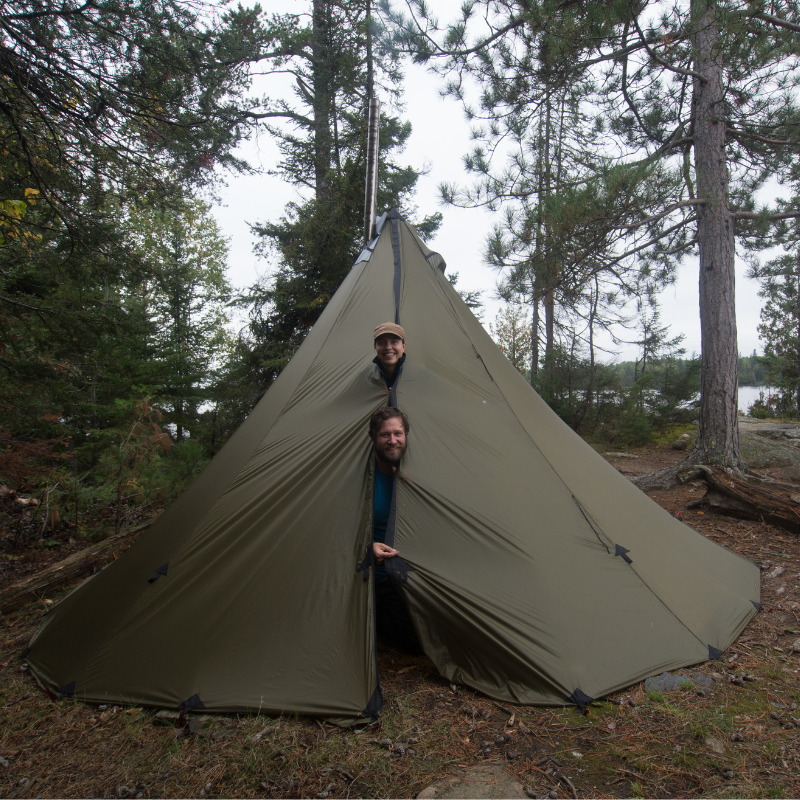 two hikers poke their heads out of the full height zipper on 8 foot 6 inch tall 8 person tipi