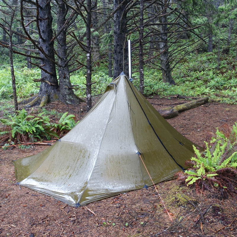 Backcountry hunting camp with Redcliff tent in steady rain, guyout loops tightened to steepen walls for weather resistance